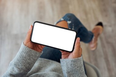 Üst görünüm görüntüsü boş beyaz ekranlı cep telefonu tutan bir kadının görüntüsü 