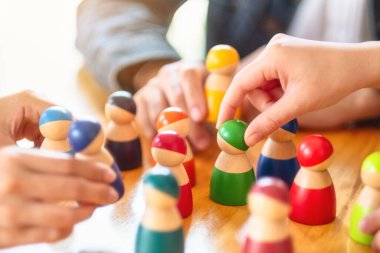 İnsanlar masadaki bir gruptan tahta figürleri seçip alıyor.