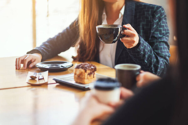 Closeup image of people enjoyed talking, eating and drinking coffee together in cafe