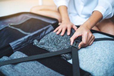 Yolculuk için bavul hazırlayan bir kadının yakın plan fotoğrafı.