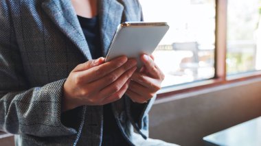 Cep telefonu tutan ve kullanan bir kadının yakın plan görüntüsü