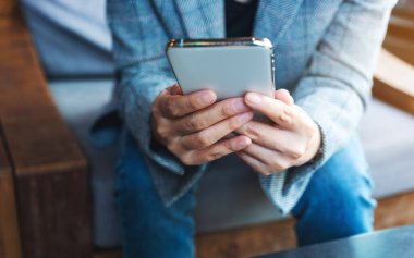 Cep telefonu tutan ve kullanan bir kadının yakın plan görüntüsü
