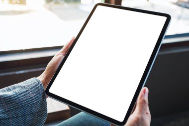 Boş beyaz masaüstü ekranlı siyah tablet bilgisayar tutan bir kadının görüntüsü