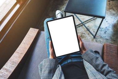 Boş beyaz masaüstü ekran ile siyah tablet pc taşıyan bir kadının en üst görünüm görüntüsü 