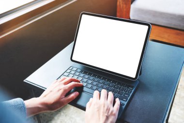 Tablet klavyesinde bilgisayar bilgisayarı olarak boş beyaz masaüstü ekran kullanan ve yazan ellerin görüntüsü