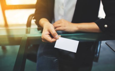 İş kadını elinde tutuyor ve birine boş bir kartvizit veriyor.
