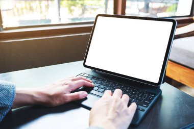Tablet klavyesinde bilgisayar bilgisayarı olarak boş beyaz masaüstü ekran kullanan ve yazan ellerin görüntüsü