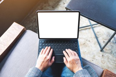 Tablet klavyesinde bilgisayar bilgisayarı olarak boş beyaz masaüstü ekran kullanan ve yazan bir kadının en üst görünüm görüntüsü 