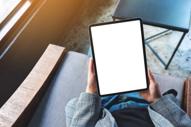 Boş beyaz masaüstü ekran ile siyah tablet pc taşıyan bir kadının en üst görünüm görüntüsü 