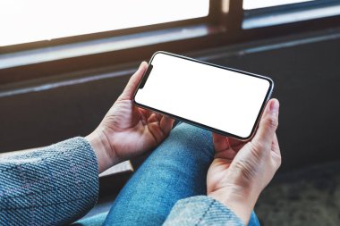 Boş beyaz masaüstü ekranlı cep telefonu tutan bir kadının görüntüsü 