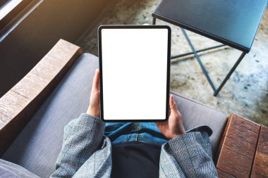 Boş beyaz masaüstü ekran ile siyah tablet pc taşıyan bir kadının en üst görünüm görüntüsü 