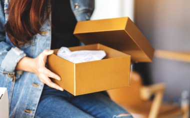 Posta kutusunu eve teslim ve online alışveriş için alan ve açan bir kadın.