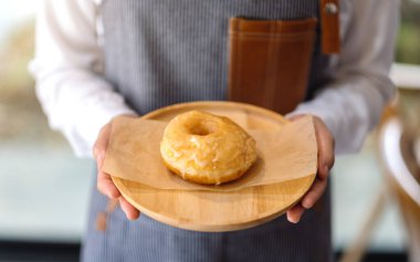 Ahşap tepside ev yapımı donut servis eden bir garson.