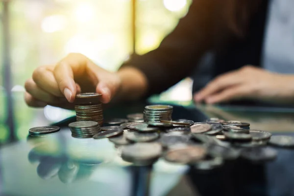 お金や金融の概念を保存するためのテーブルの上にコインを数えると積み重ねるビジネスマンの女性 — ストック写真