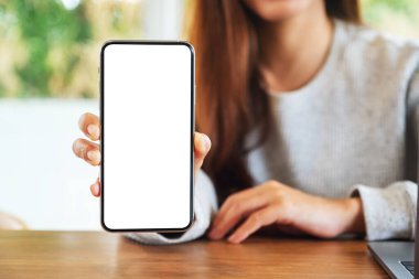 Güzel bir kadının boş beyaz ekranlı cep telefonunu tutarken ve gösterirken ki görüntüsü. 