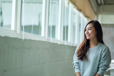 Kafede oturmuş mutlu bir Asyalı kadının portresi.