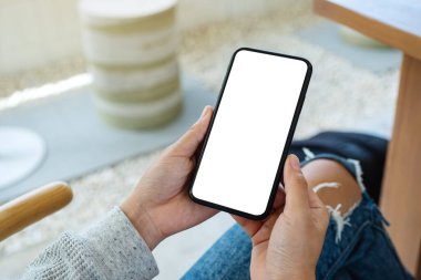 Boş beyaz masaüstü ekranlı cep telefonu tutan bir kadının görüntüsü 