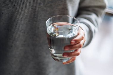 Yakından bakınca, elinde bir bardak saf su tutan bir kadın görülüyor. 