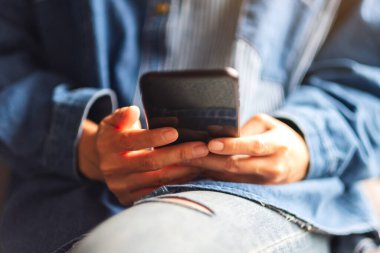 Cep telefonu tutan ve kullanan bir kadının yakın plan görüntüsü