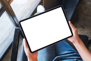 Boş beyaz masaüstü ekran ile siyah tablet pc taşıyan bir kadının en üst görünüm görüntüsü 