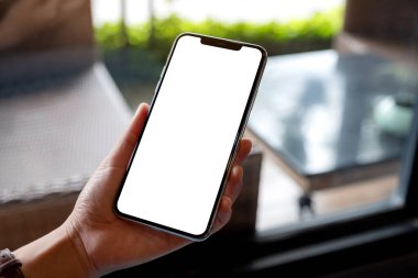 Boş beyaz masaüstü ekranlı cep telefonu tutan bir kadının görüntüsü 