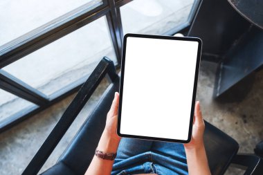 Boş beyaz masaüstü ekran ile siyah tablet pc taşıyan bir kadının en üst görünüm görüntüsü 