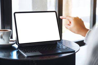 Boş masaüstü beyaz ekranı bilgisayar bilgisayarı olarak kullanan ve parmağıyla tableti işaret eden bir kadının görüntüsü 