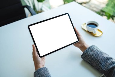 Ofiste boş beyaz masaüstü ekranı olan tablet bilgisayarı tutan bir kadının görüntüsü