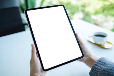 Ofiste boş beyaz masaüstü ekranı olan tablet bilgisayarı tutan bir kadının görüntüsü