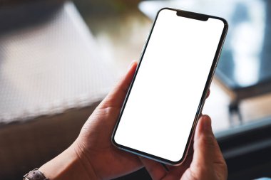 Boş beyaz masaüstü ekranlı cep telefonu tutan bir kadının görüntüsü 