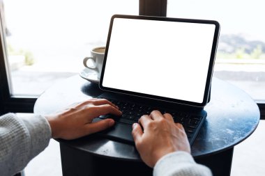 Tablet klavyesinde boş beyaz masaüstü ekranı bir bilgisayar bilgisayarı olarak kullanan ve yazan bir kadının görüntüsü