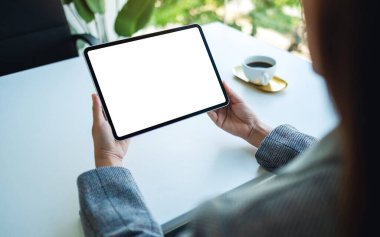 Ofiste boş beyaz masaüstü ekranı olan tablet bilgisayarı tutan bir kadının görüntüsü