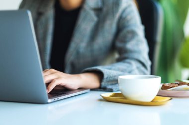 Ofiste dizüstü bilgisayar kullanan ve çalışan bir iş kadınının yakın plan görüntüsü 