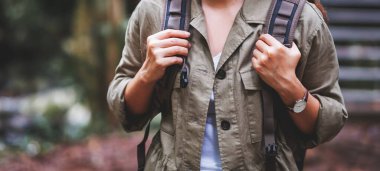 Sırt çantalı bir kadın gezgin dağ deresinde yürüyüş konsepti için yürüyor.