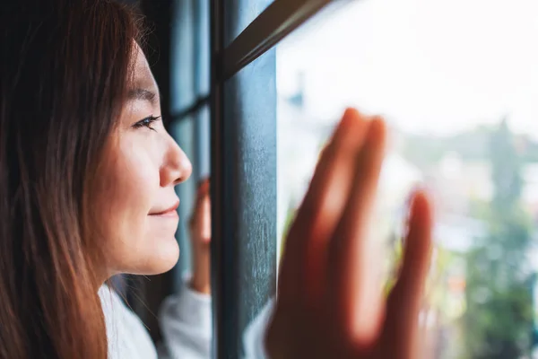 Image Rapprochée Une Jeune Femme Touchant Fenêtre Regardant Extérieur — Photo