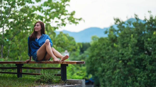 stock image Portrait image of a beautiful young asian woman with mountains and green nature background