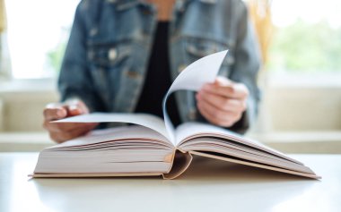 Oturup kitap okuyan bir kadının yakın plan görüntüsü. 