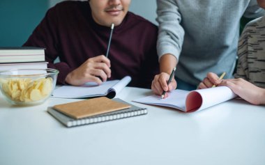 Bir grup genç öğrenci ders veriyor ve arkadaşlarıyla ders çalışıyor.