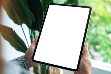 Boş beyaz masaüstü ekranlı dijital tableti tutan bir kadının görüntüsü