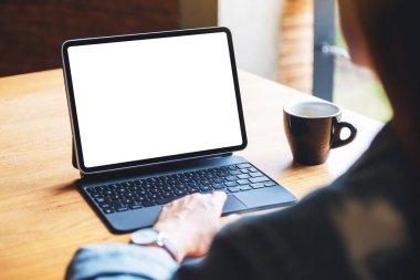 Ofiste bilgisayar bilgisayarı olarak boş beyaz masaüstü ekranı olan tablet dokunmatik ekranda dokunan bir kadının görüntüsü