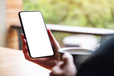 Boş beyaz masaüstü ekranlı cep telefonu tutan bir kadının görüntüsü