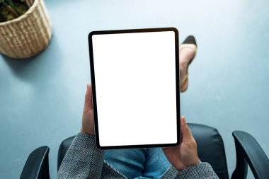 Boş beyaz masaüstü ekran ile dijital tablet tutan bir iş kadınının üst görünüm görüntüsü