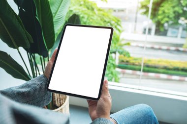 Boş beyaz masaüstü ekranlı dijital tableti tutan bir kadının görüntüsü