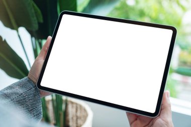 Boş beyaz masaüstü ekranlı dijital tableti tutan bir kadının görüntüsü