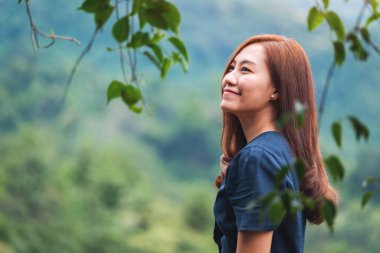 Güzel yeşil dağ manzaralı Asyalı bir kadının portresi.