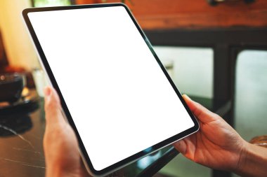 Boş beyaz masaüstü ekranlı dijital tableti tutan bir kadının görüntüsü