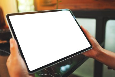 Boş beyaz masaüstü ekranlı dijital tableti tutan bir kadının görüntüsü