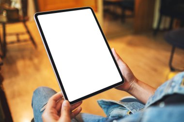 Boş beyaz masaüstü ekranlı dijital tableti tutan bir kadının görüntüsü