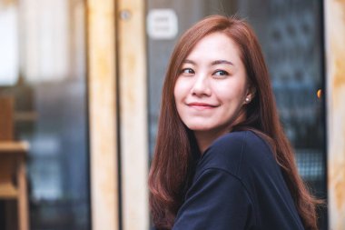 Açık havada oturan Asyalı güzel bir kadının portresi.