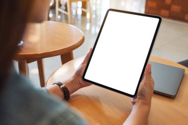 Boş beyaz masaüstü ekranlı dijital tableti tutan bir kadının görüntüsü